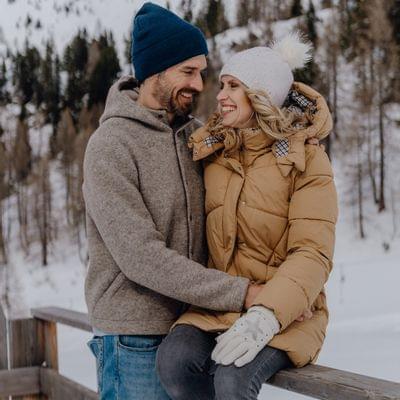 Smiling couple in winter clothing with snowy mountain background